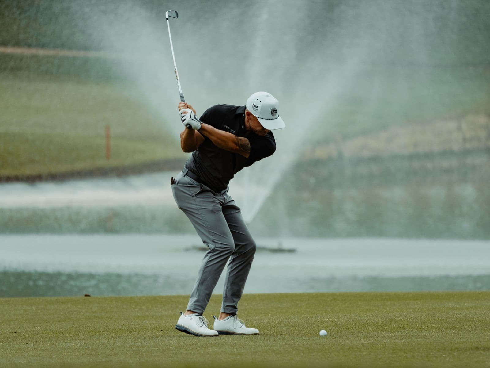 A golfer making a confident swing on a summer course